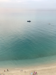 A peaceful beach scene at Dahab with turquoise waters and colorful boats resting on the shore.