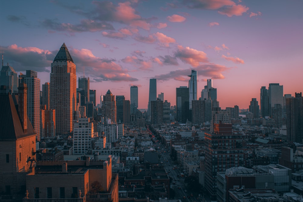 city skyline under cloudy sky during sunset