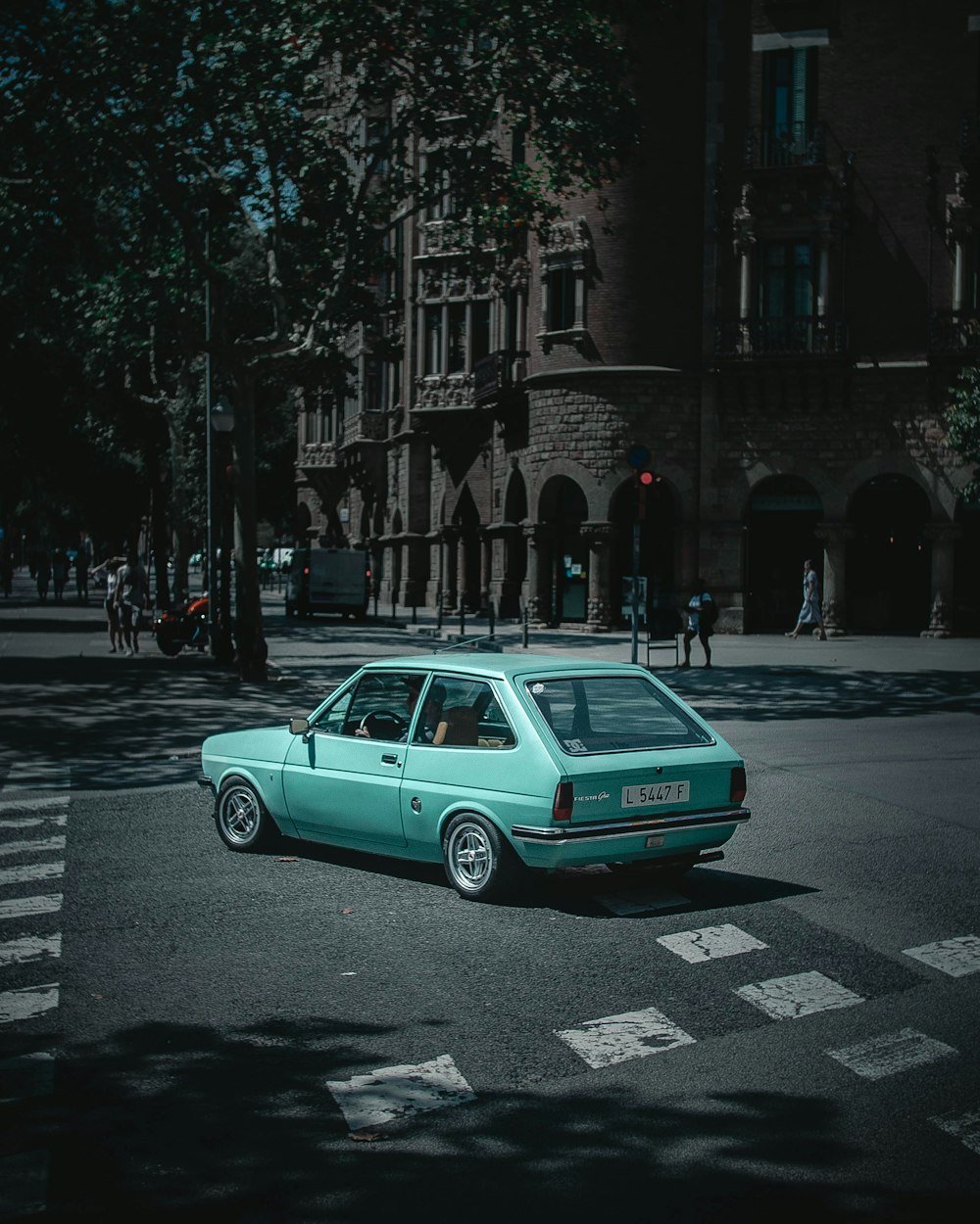 blue sedan on road near building during daytime