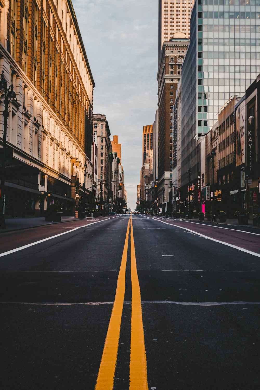 cars on road between high rise buildings during daytime