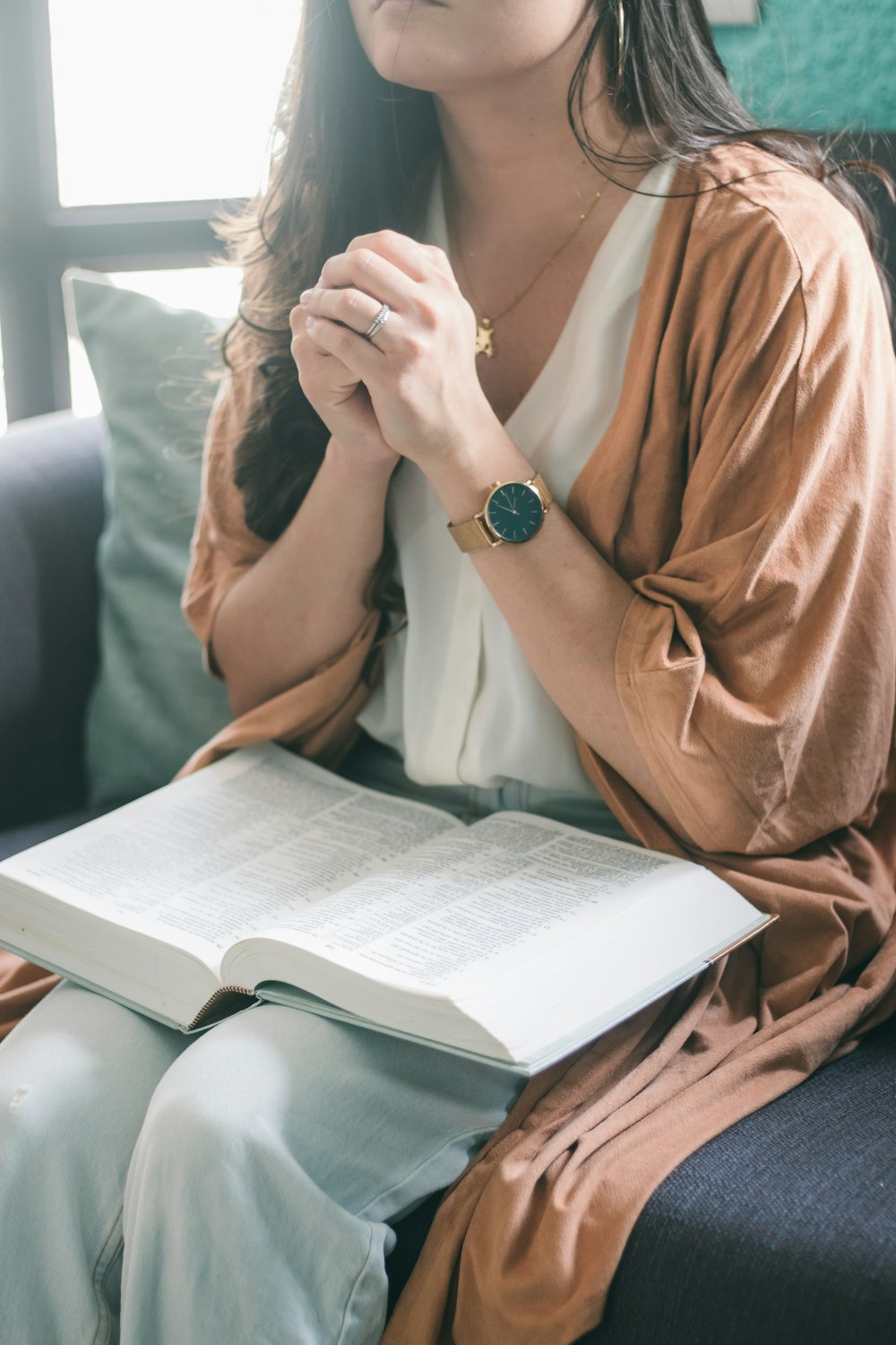 woman in brown robe sitting on black leather couch