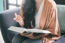 woman in orange blazer sitting on sofa
