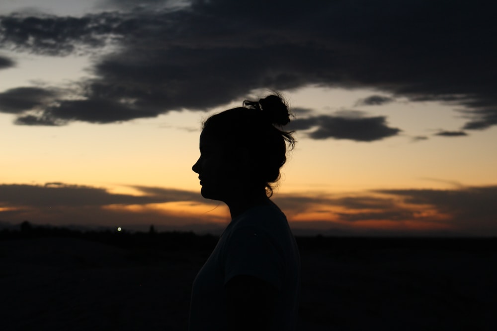 silhouette of woman standing during sunset