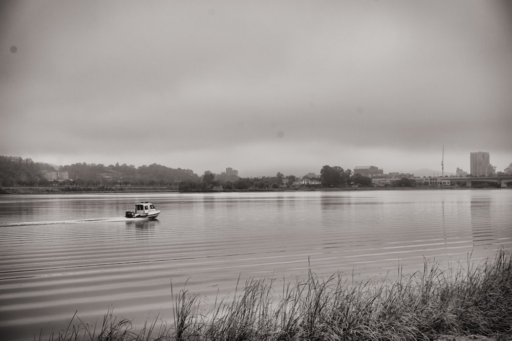 grayscale photo of boat on lake