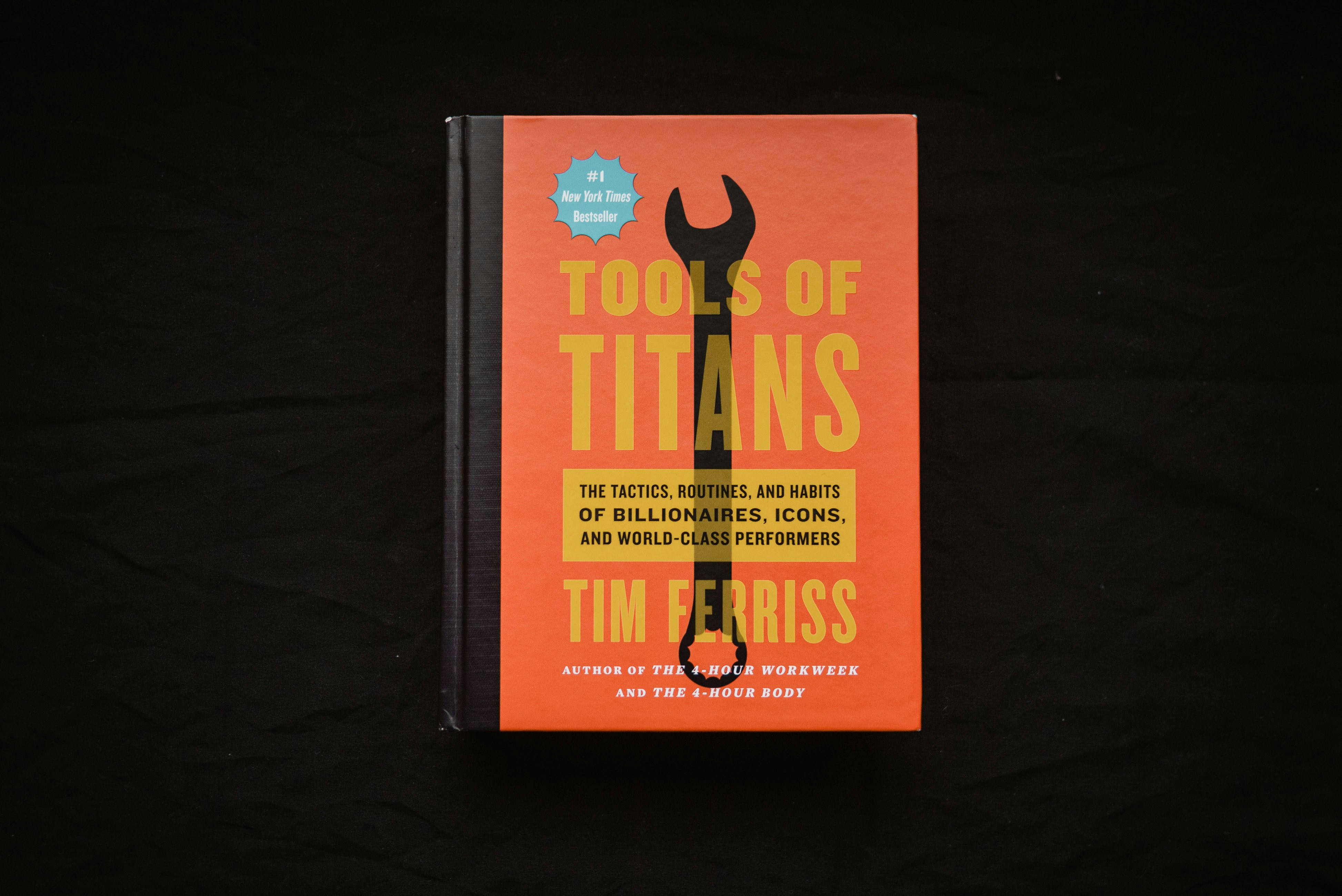 a book about tools of titans on a black background (Photo by JC Falcon on Unsplash)