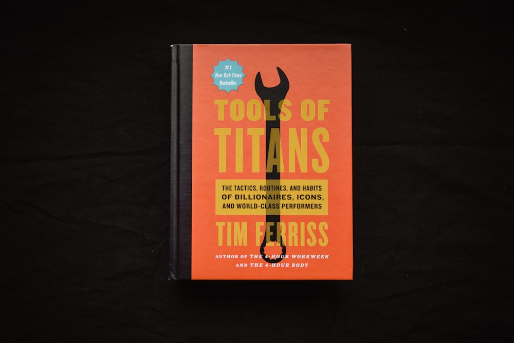 a book about tools of titans on a black background