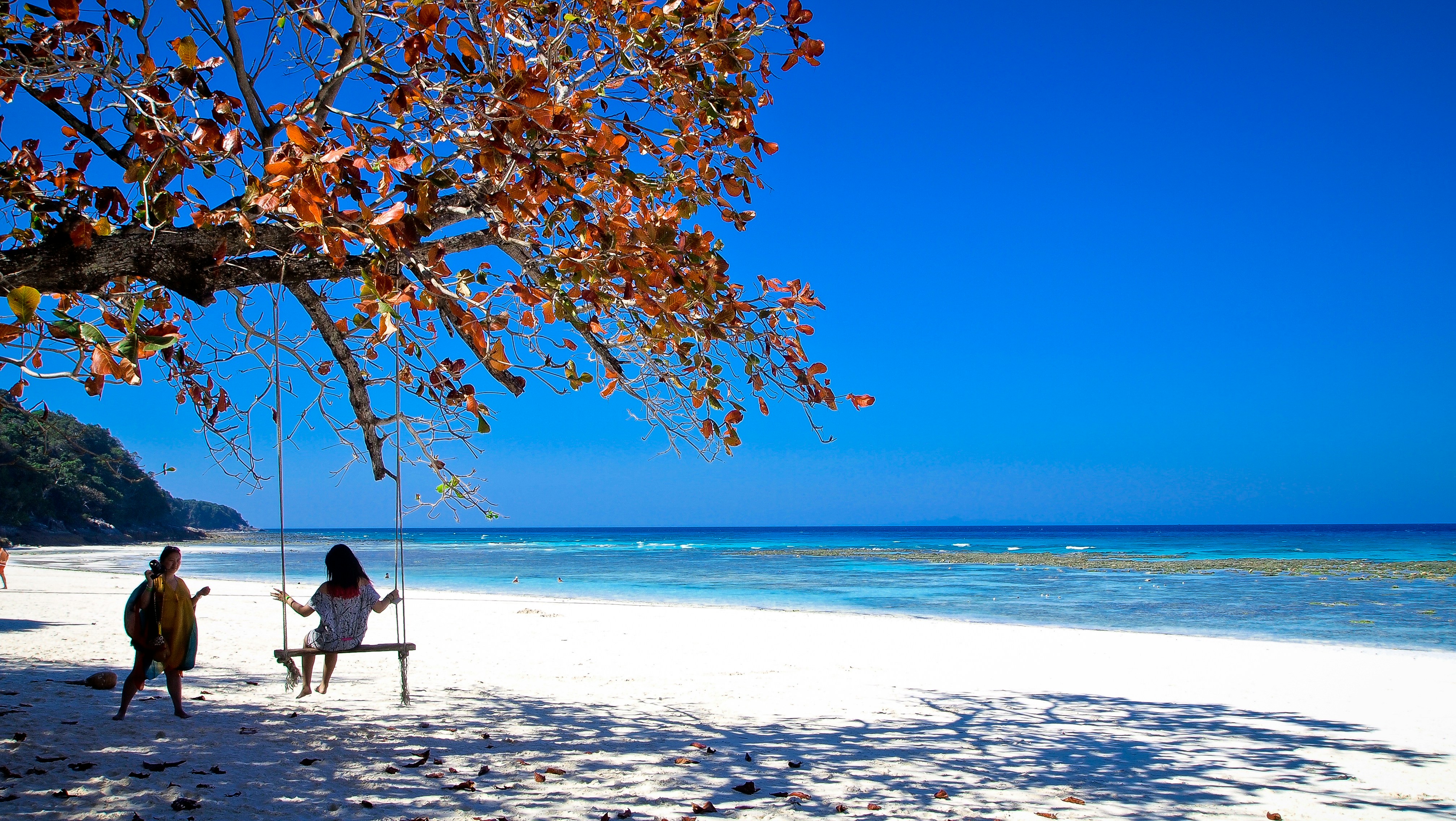 person in black jacket sitting on swing chair under blue sky during daytime