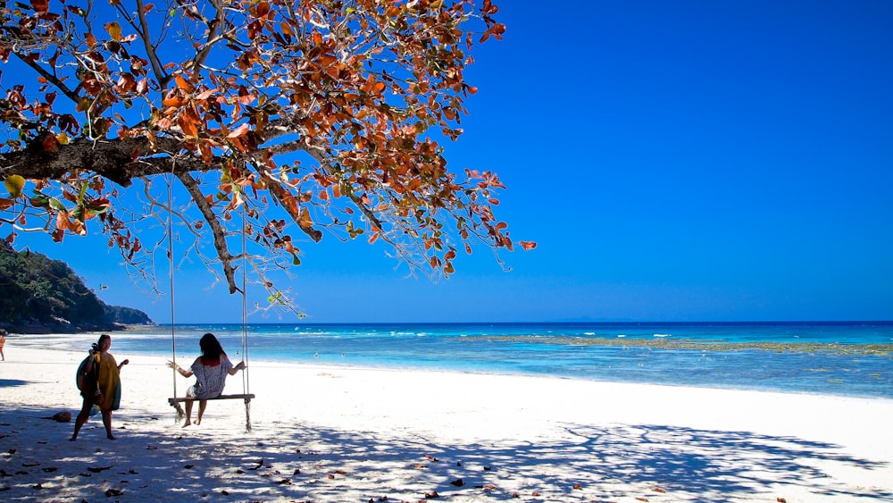 person in black jacket sitting on swing chair under blue sky during daytime