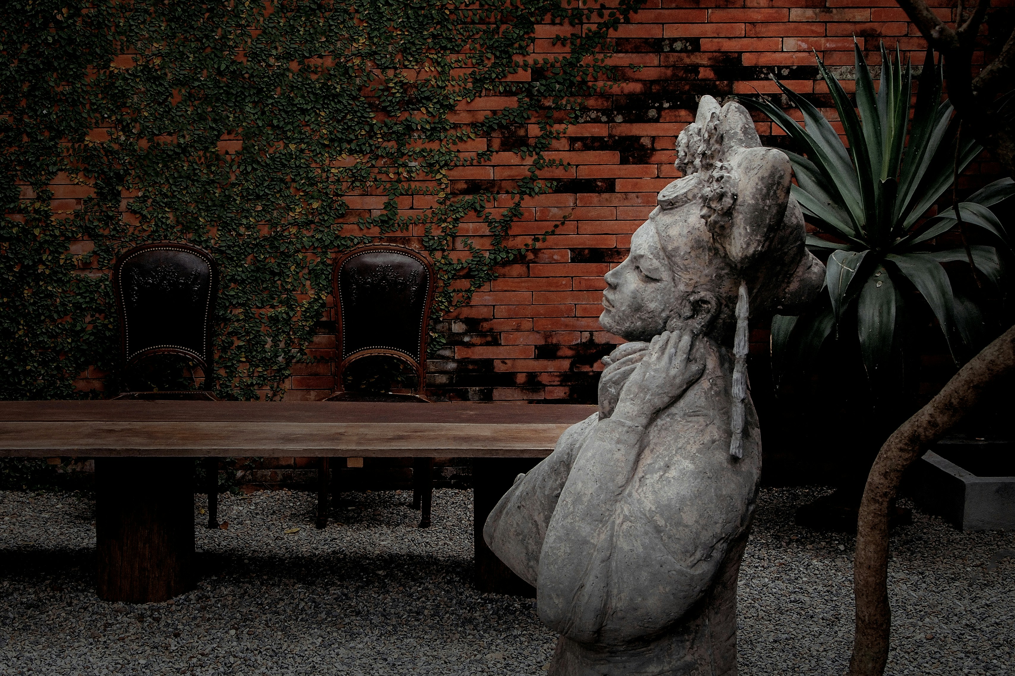 brown wooden bench beside brown concrete wall