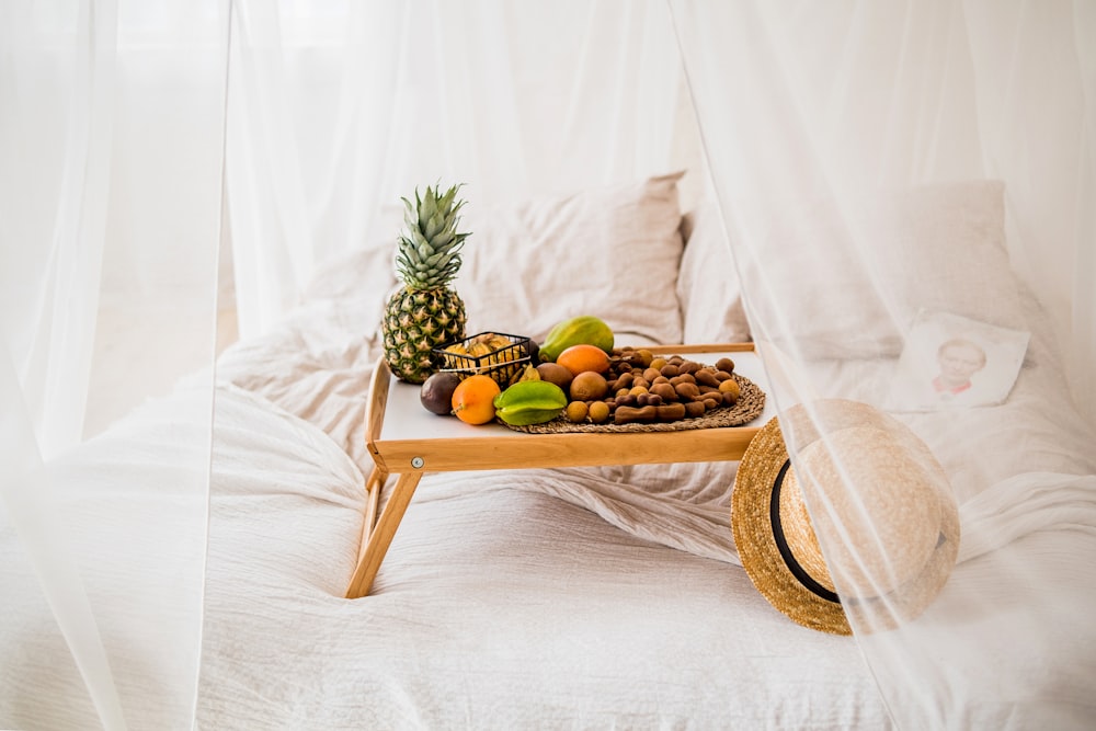 fruits on brown wooden tray on white textile