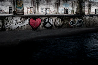 An abandoned, graffiti-covered building with broken windows reflecting a blood-red sunset.