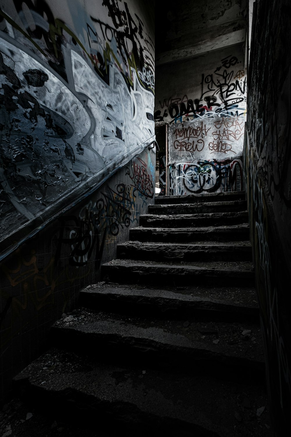 Escalera negra con pintura mural blanca y azul
