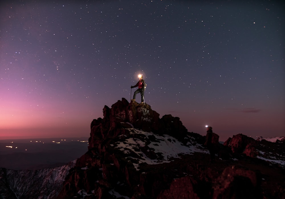 person standing on rocky hill during night time