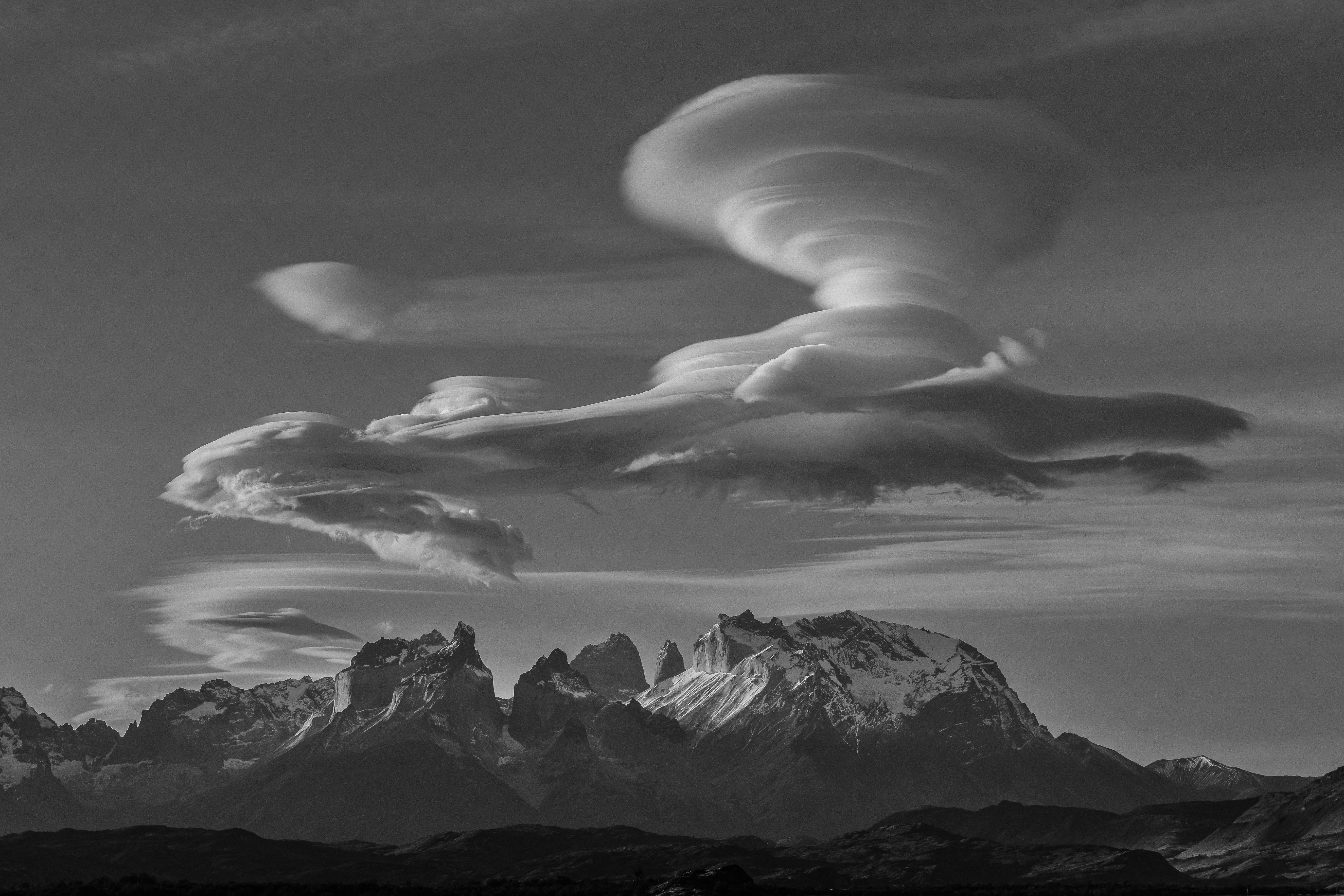 grayscale photo of mountains and clouds