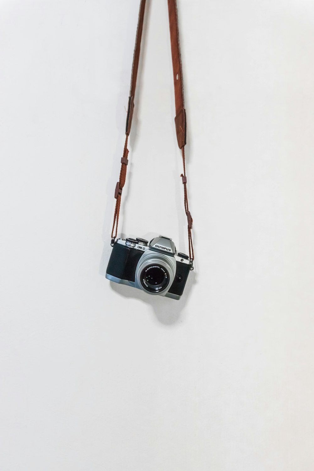 black and silver camera hanging on brown rope
