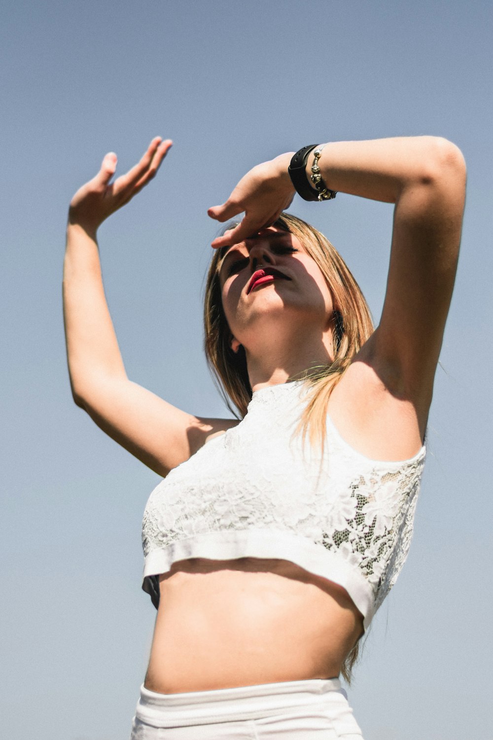 woman in white crop top and white shorts with red manicure
