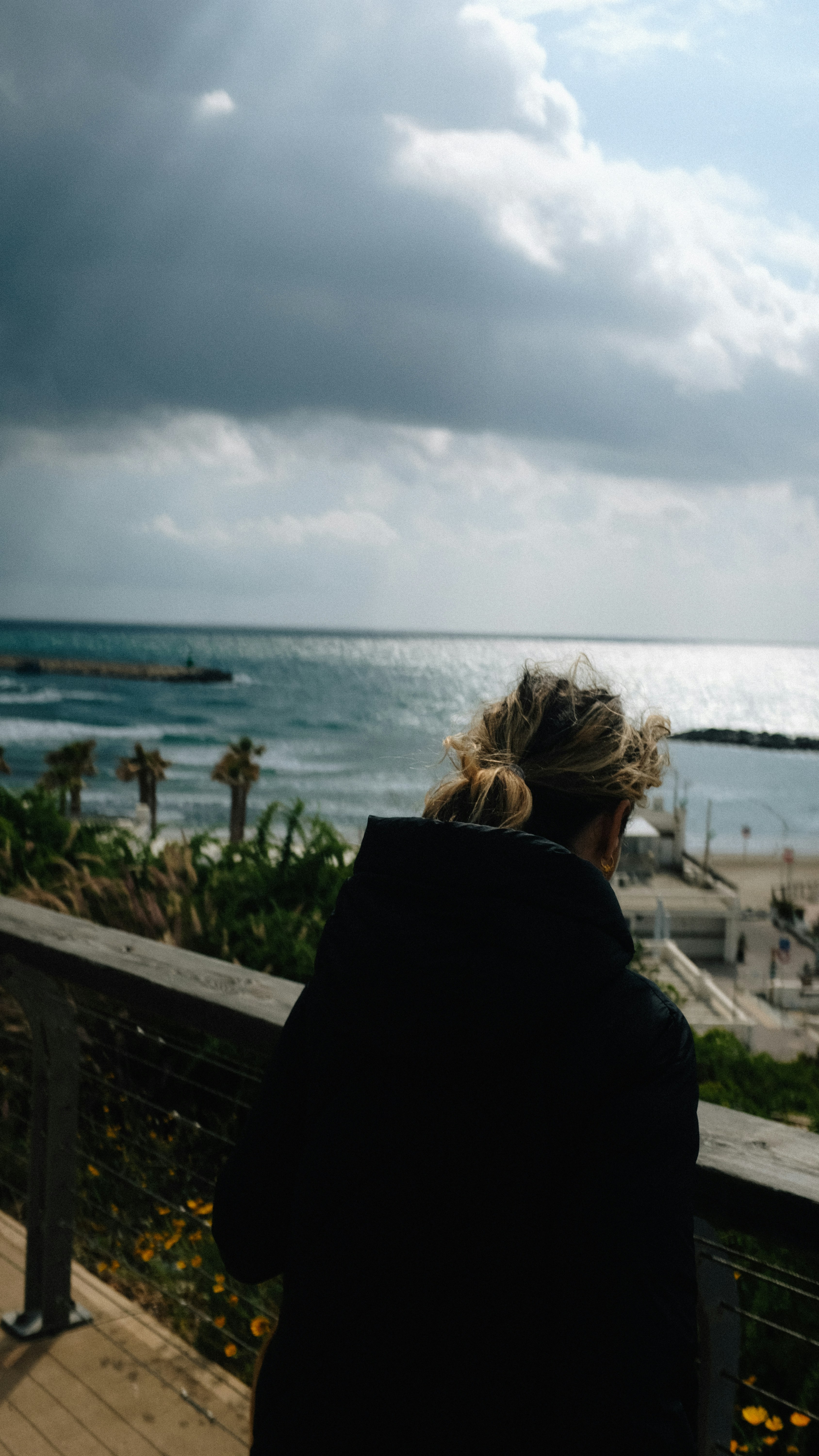 woman in black jacket standing near body of water during daytime