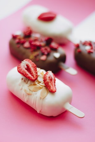 white and red ice cream on pink cone