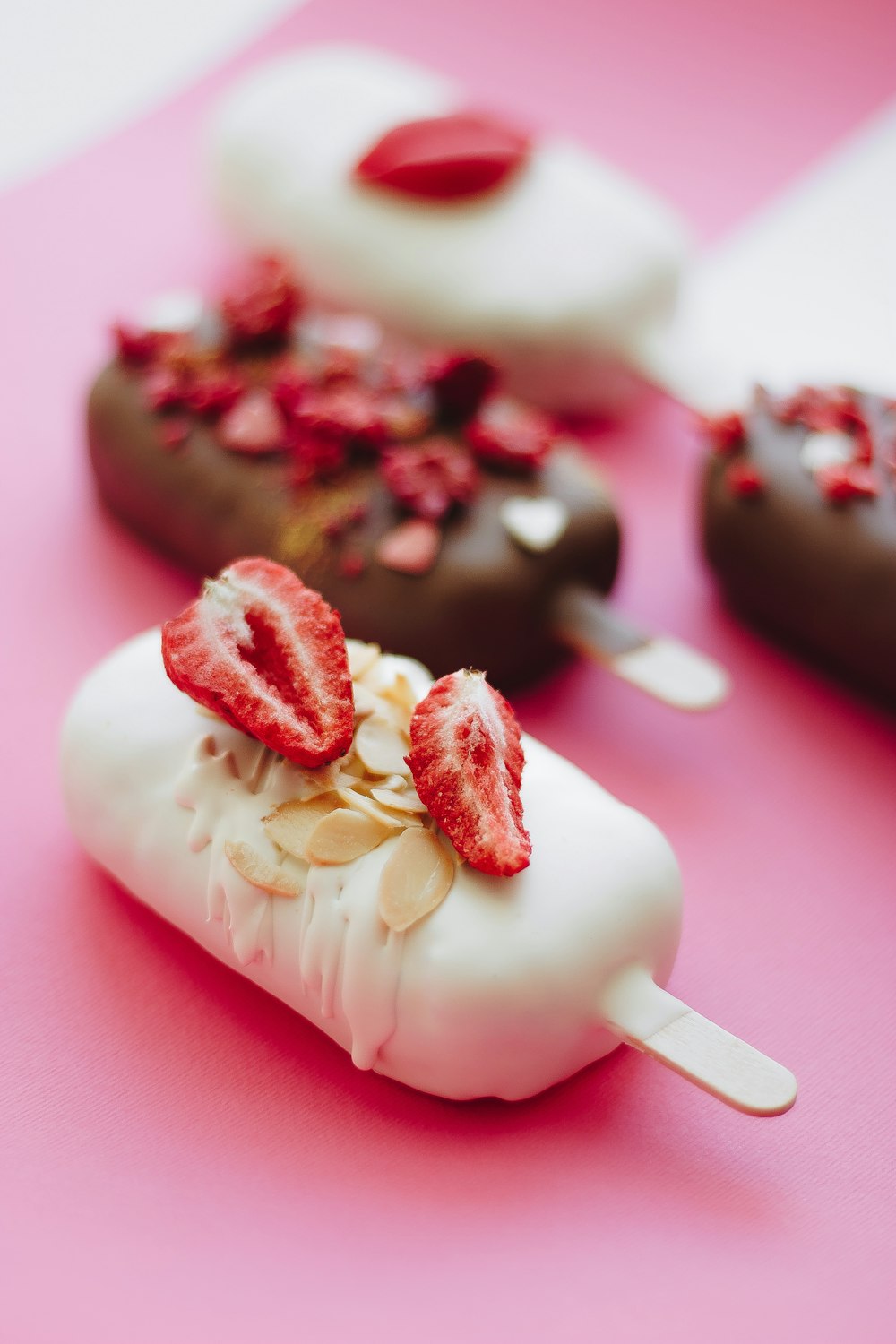 white and red ice cream on pink cone