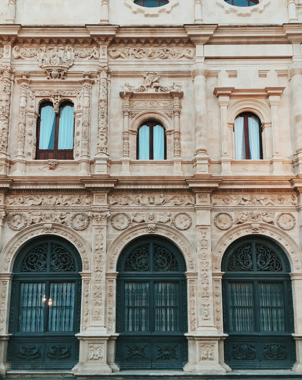 edifício de concreto bege com janelas azuis