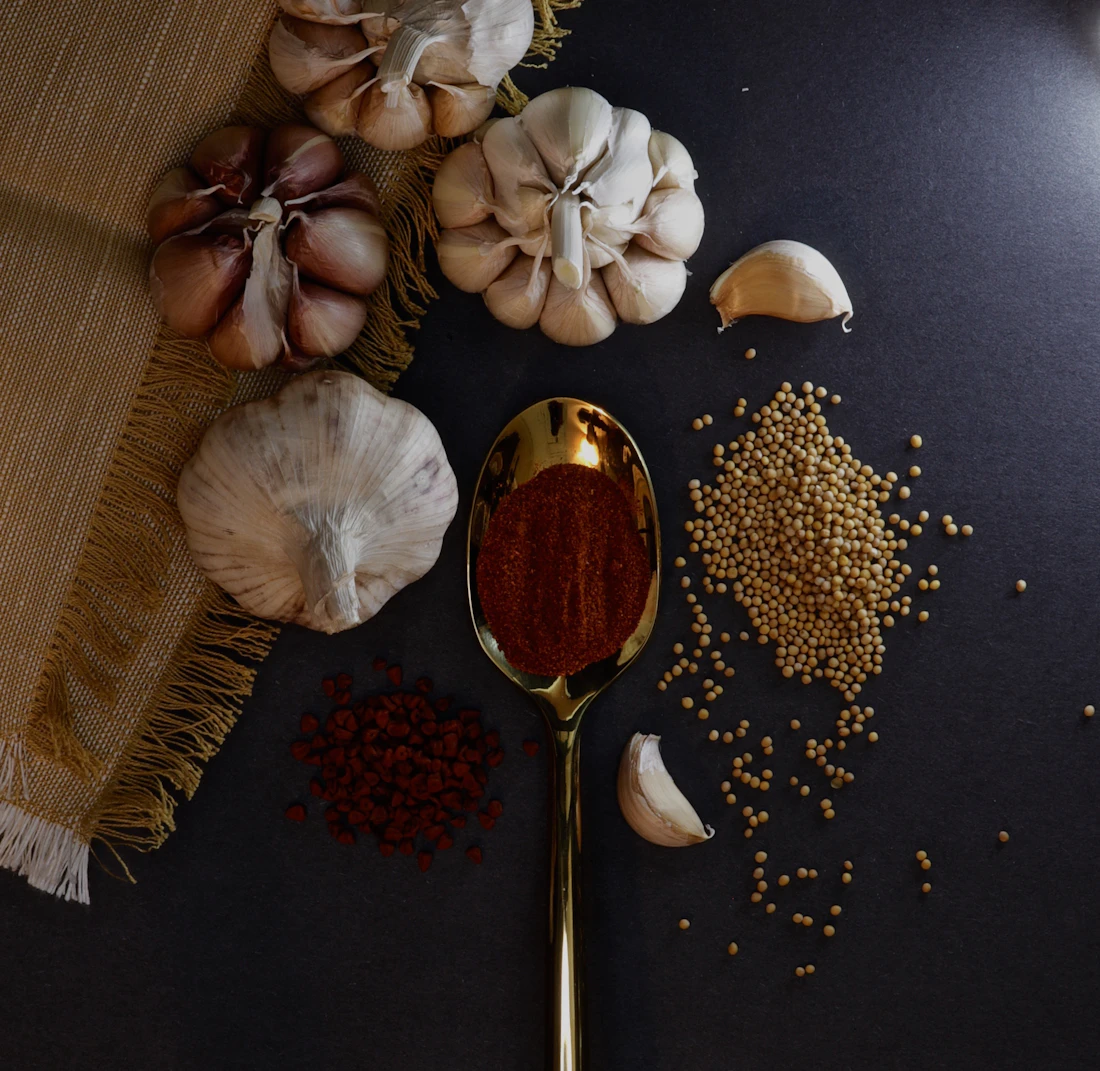 Garlic bulbs and cloves on a dark textile