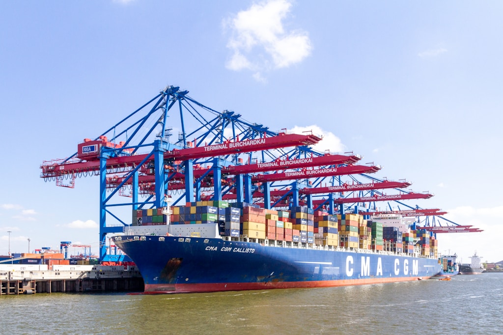 blue and red cargo ship on dock during daytime