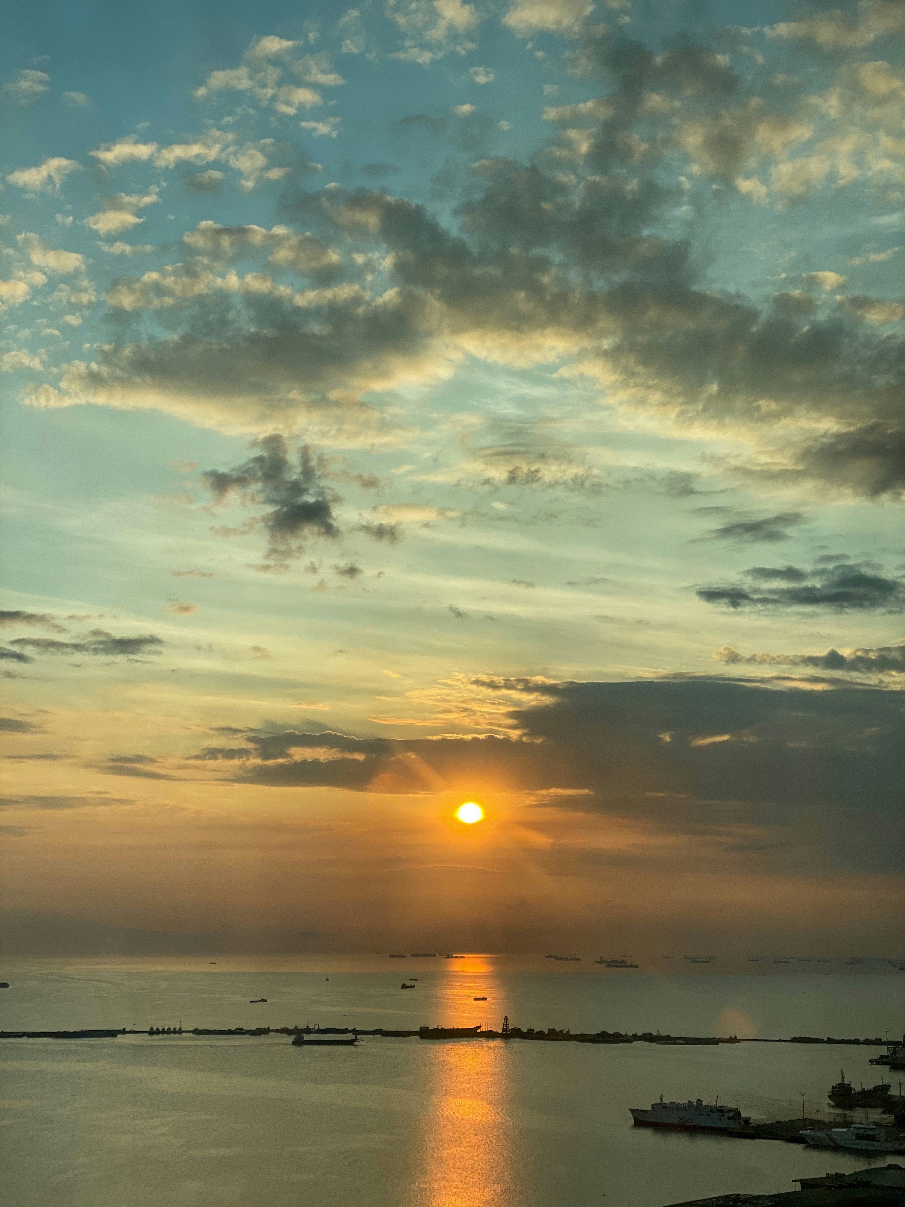 body of water under cloudy sky during sunset