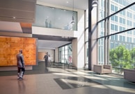 man in black jacket walking on white tiled floor