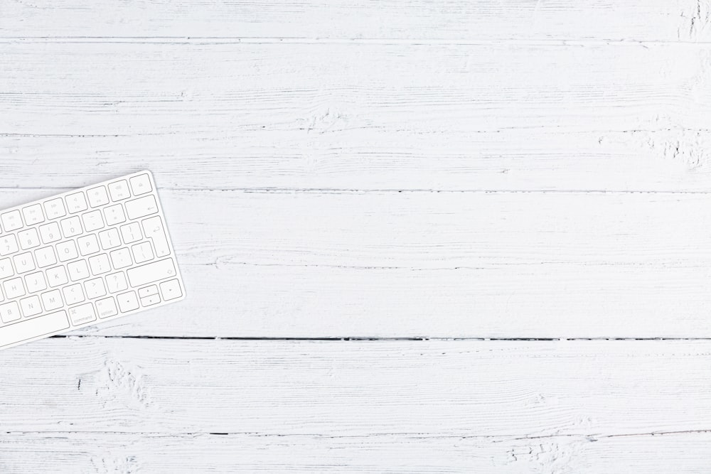 silver computer keyboard on white wooden table