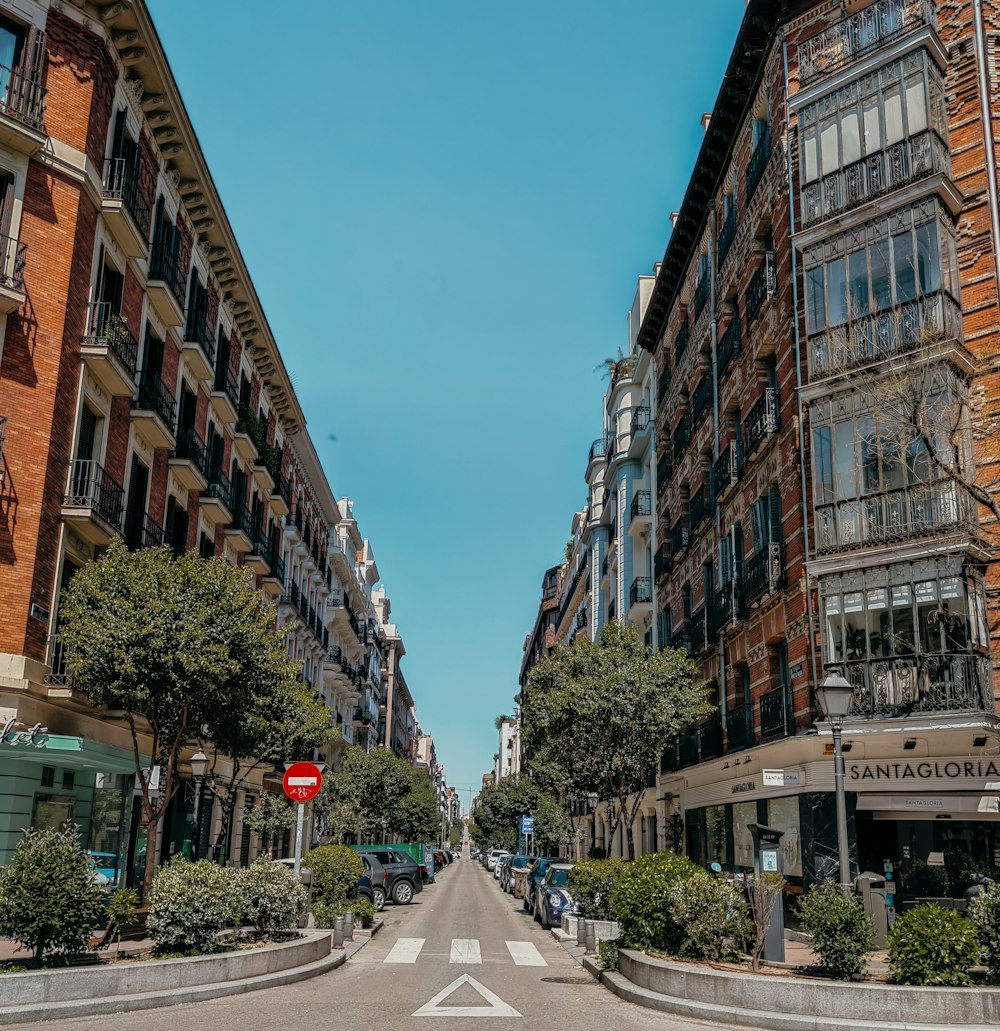 people walking on street between brown concrete buildings during daytime