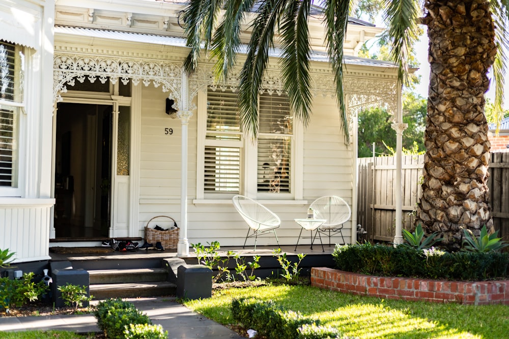 white wooden house with green plants