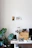 A bright workspace featuring a handmade wooden desk organizer and potted plants on a light oak surface.