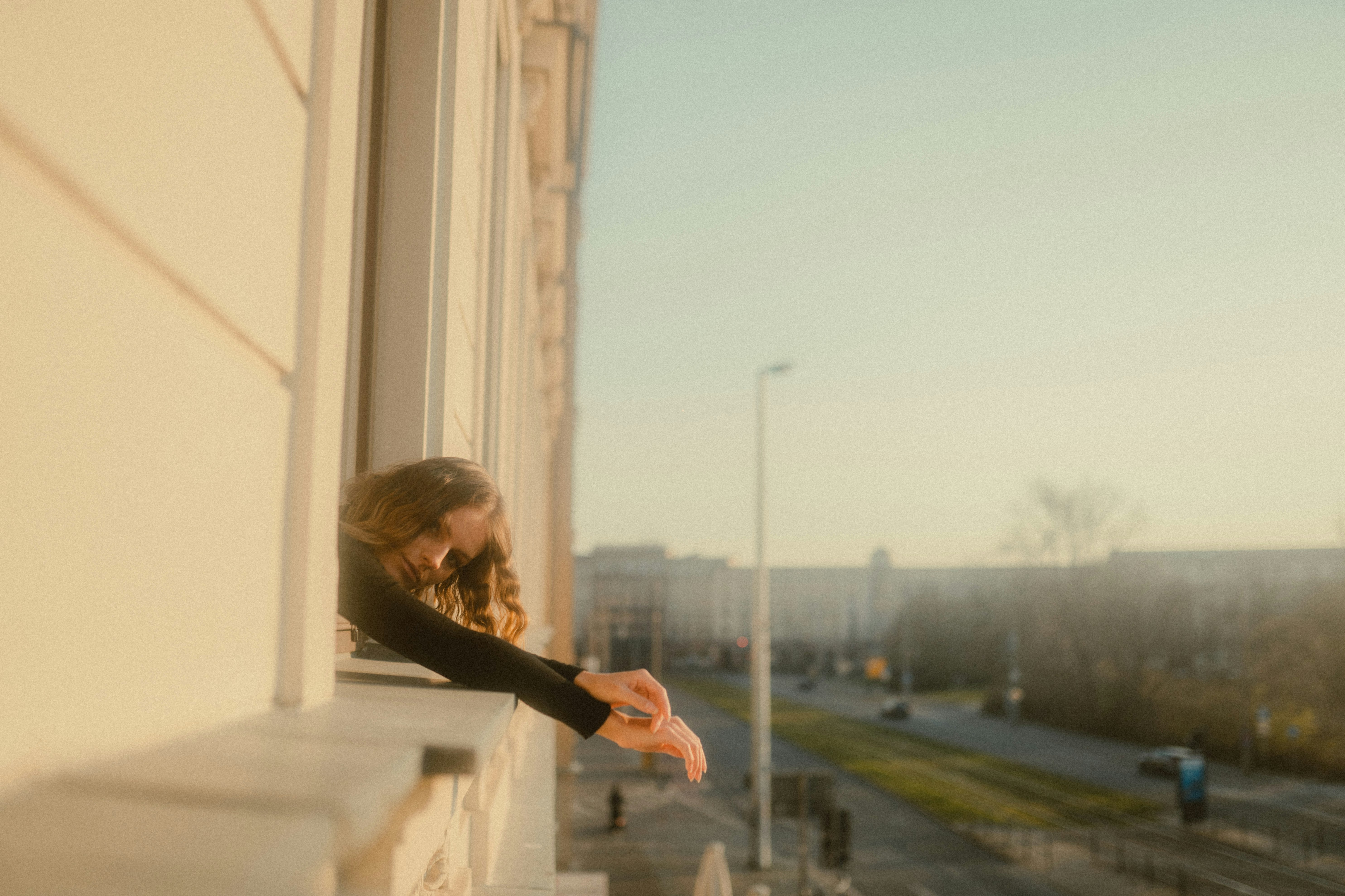 woman in black long sleeve shirt standing near white concrete building during daytime