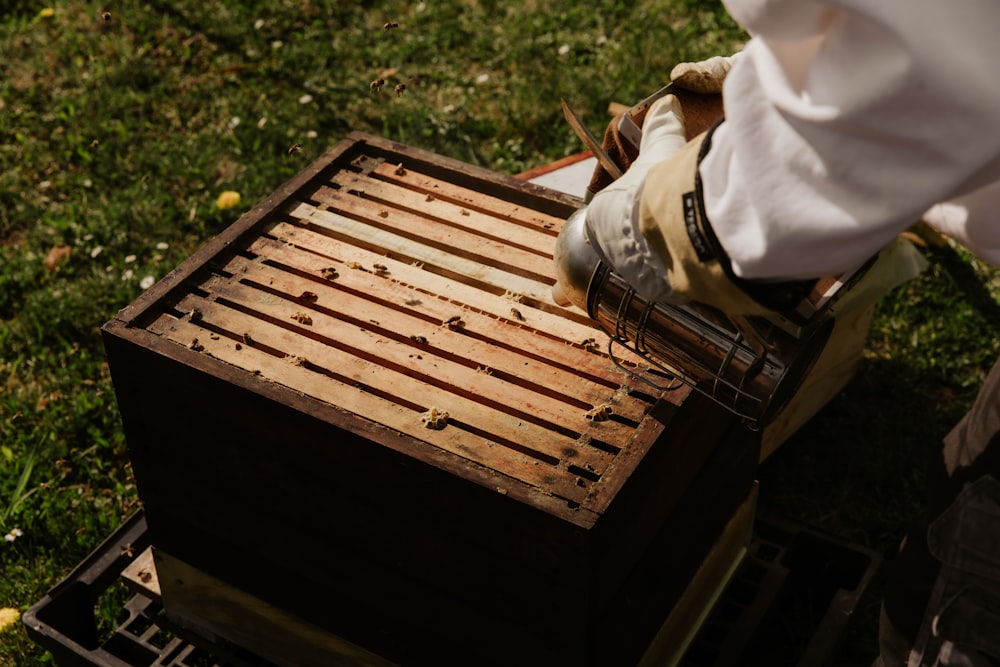 person in white long sleeve shirt and brown pants standing on brown wooden pallet