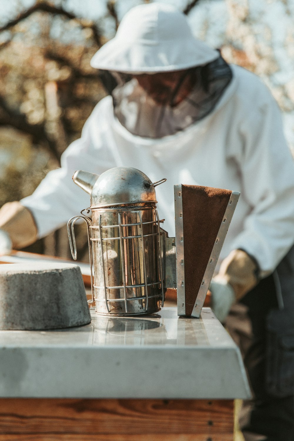 person in white long sleeve shirt holding stainless steel teapot