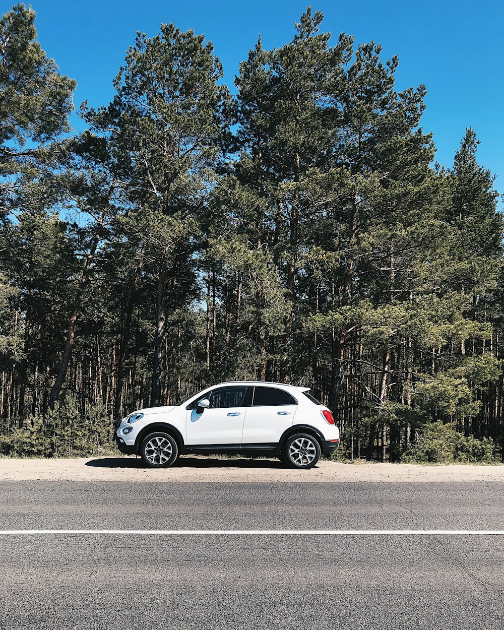 Un coche blanco aparcado al costado de la carretera