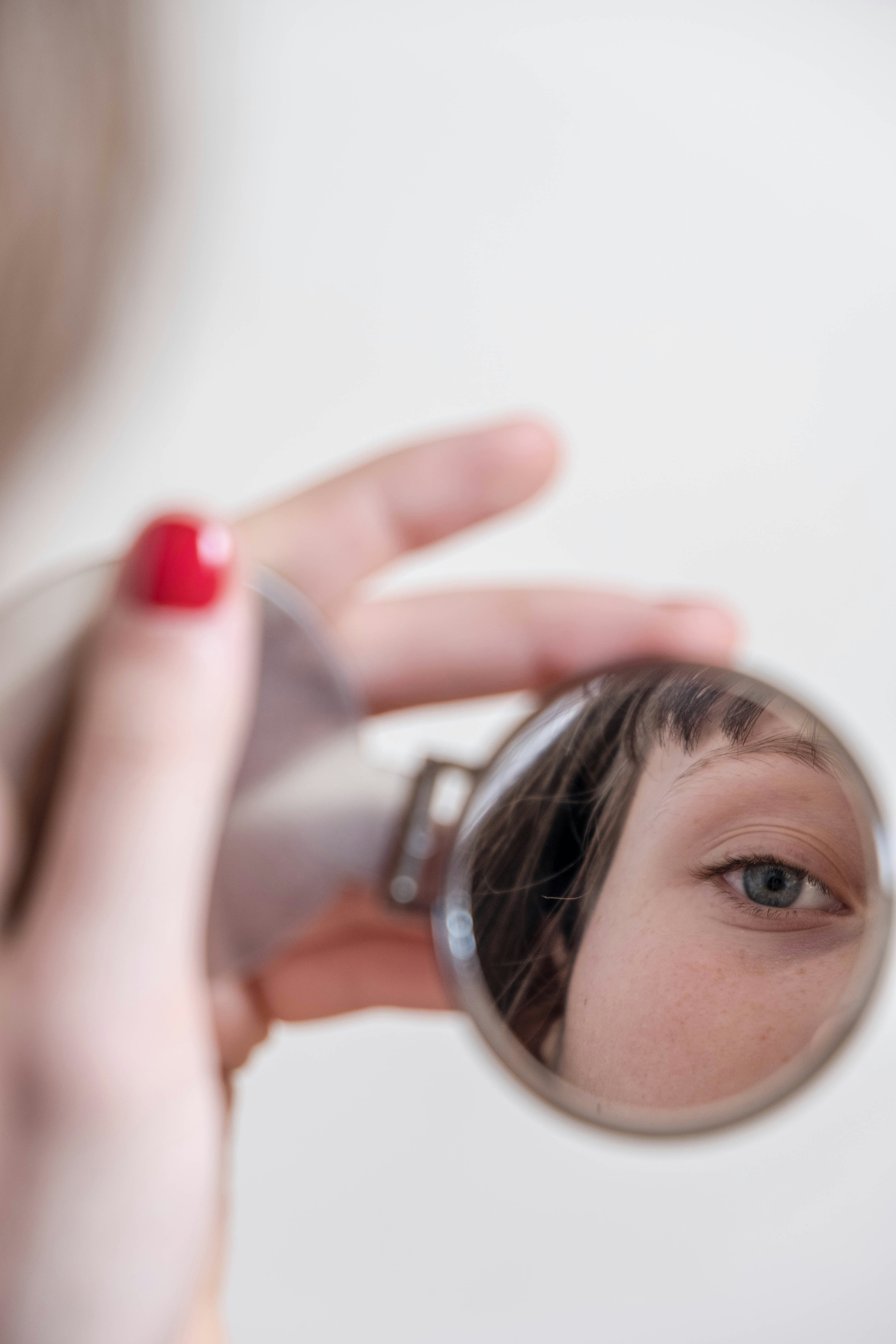 woman holding magnifying glass with red lipstick