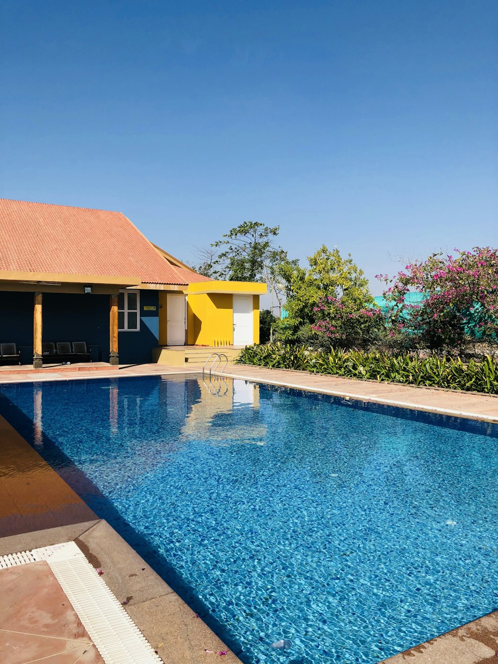 brown and white house near swimming pool during daytime