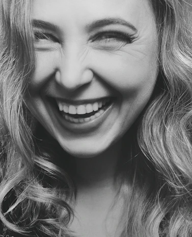 A vibrant, candid portrait of a person laughing, full of personality and life.