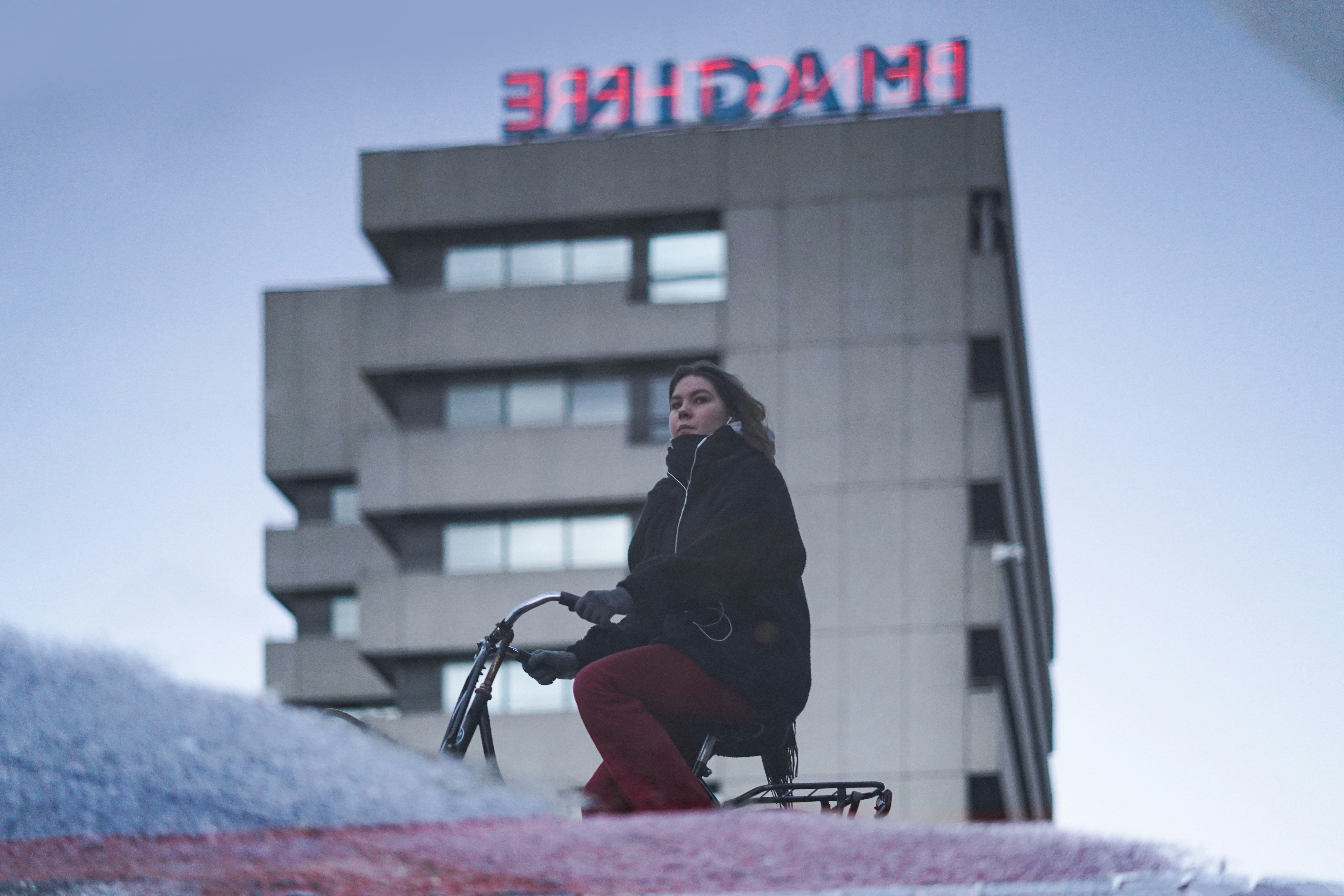 woman in black jacket riding on black bicycle during daytime
