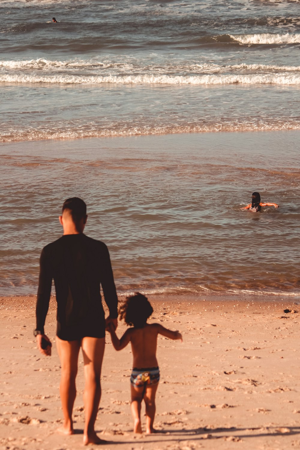 man in black shirt standing on beach during daytime