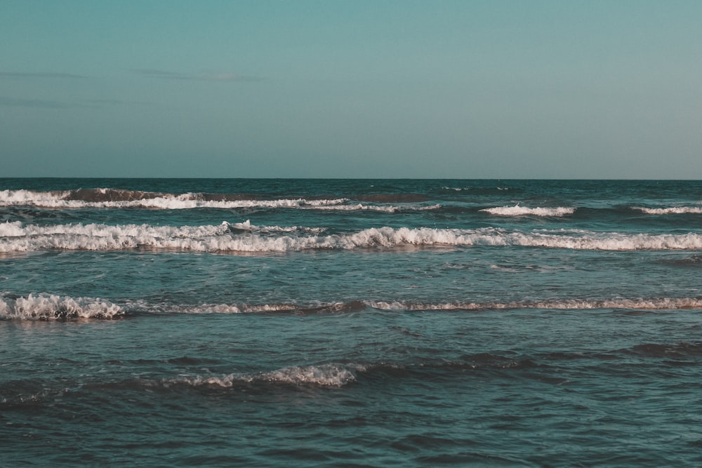 ocean waves crashing on shore during daytime