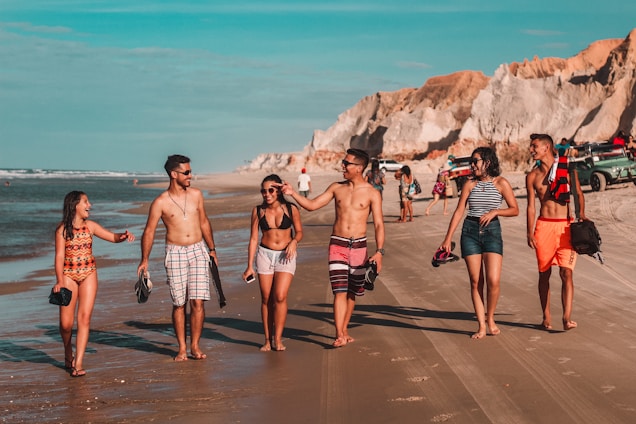 A lively group of travelers enjoying a sunny beach resort, smiling and chatting together.