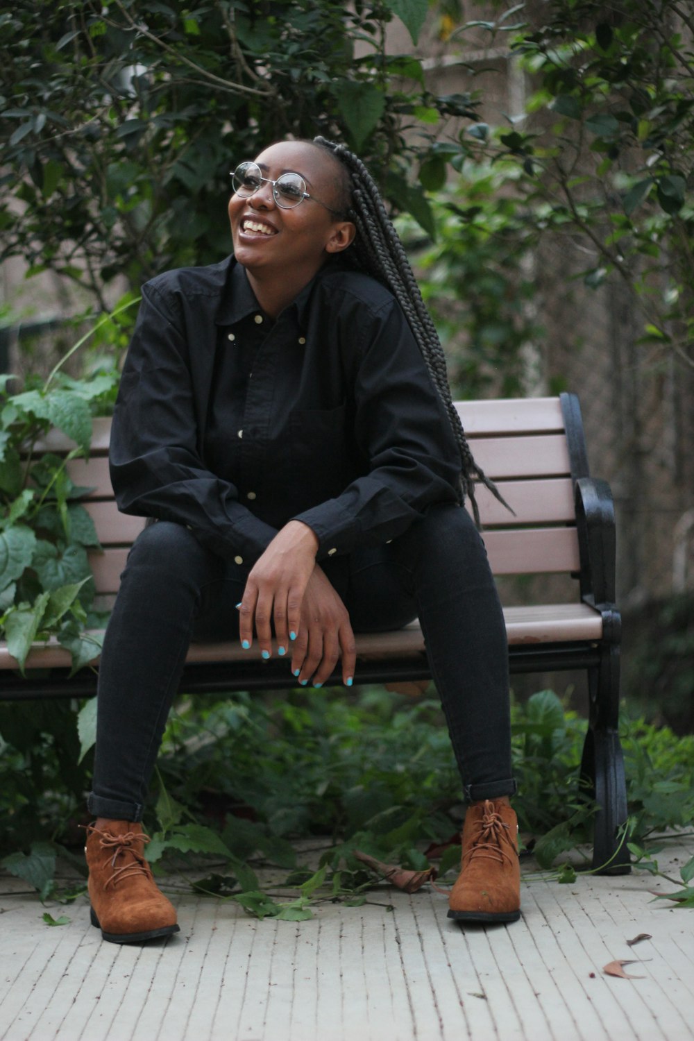 man in black dress shirt and black pants sitting on brown wooden bench