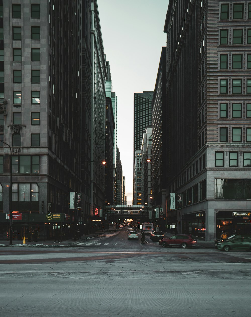 cars on road between high rise buildings during daytime