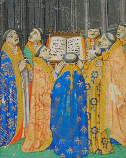 Congregants gathered in deep royal blue and burgundy robes around the altar for the Eucharist.