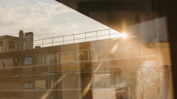 Sunlight streaming through spotless windows of a high-rise building maintained by švaros tiltas team.