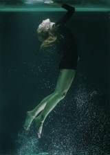 woman in black shirt and green shorts in water