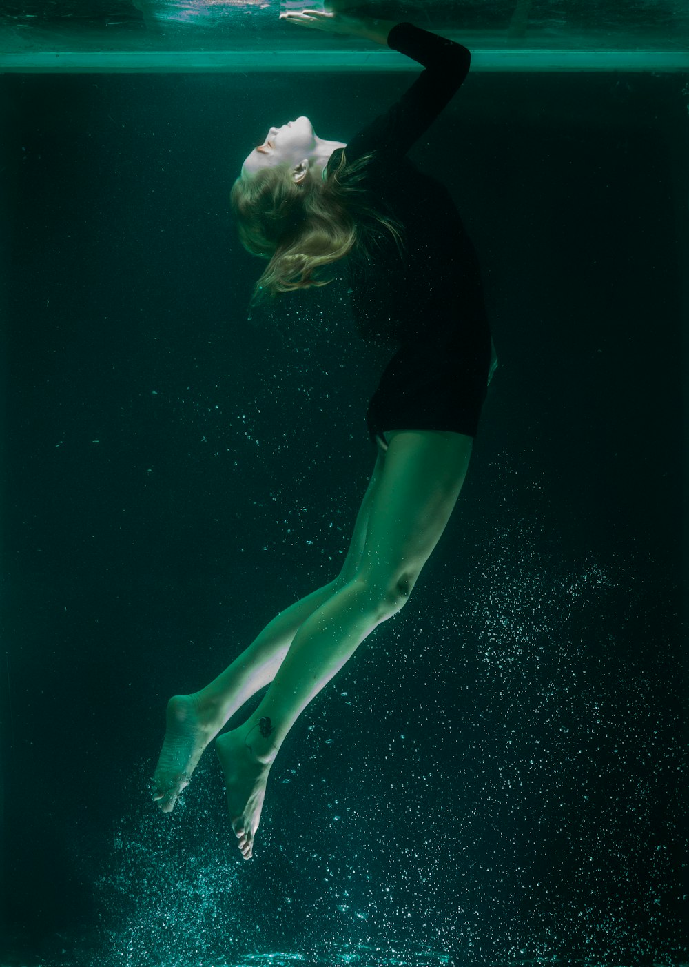 woman in black shirt and green shorts in water