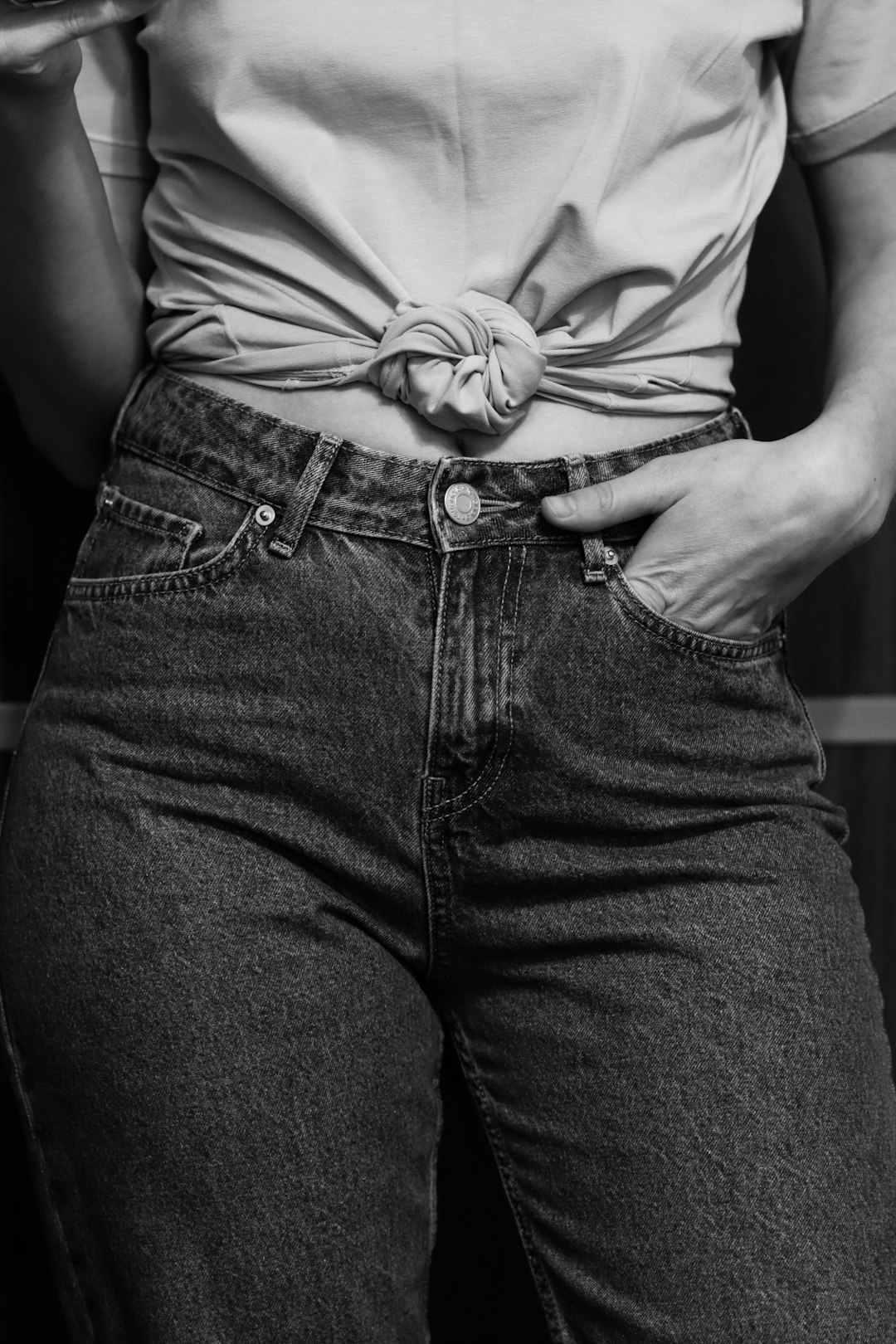 grayscale photo of woman in white shirt and denim jeans